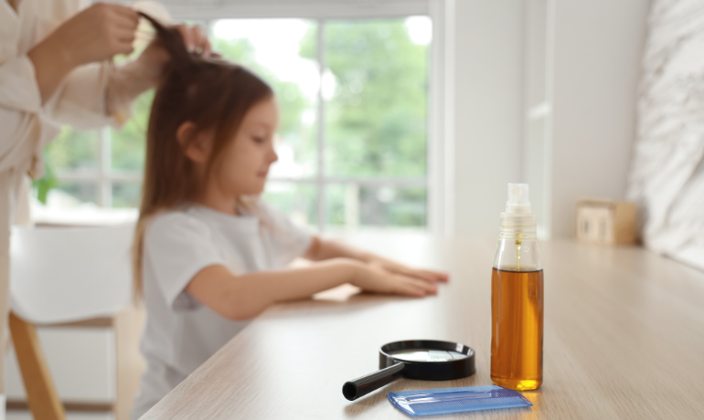 فحص شعر طفلة باستخدام مشط الصيبان والعدسة المكبرة مع بخاخ وقاية لمنع انتشار القمل.